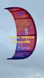 F-One Trigger Brainchild Kite im Himmel mit blauem Hintergrund, Kitesurf-Review-Text überlagert
