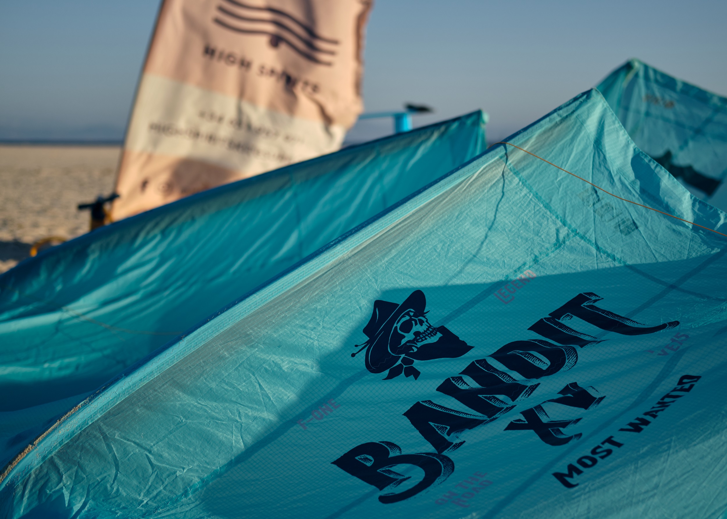 Najnowszy sprzęt F-One Bandit i flaga High Spirits Kitesurf na plaży w Tarifie podczas lekcji kitesurfingu.