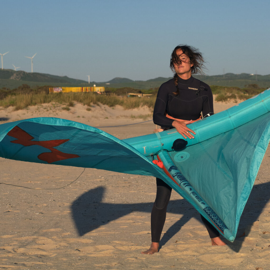 Ola ayudando a un cliente con un nuevo F-One Bandit durante el alquiler de material en Tarifa.