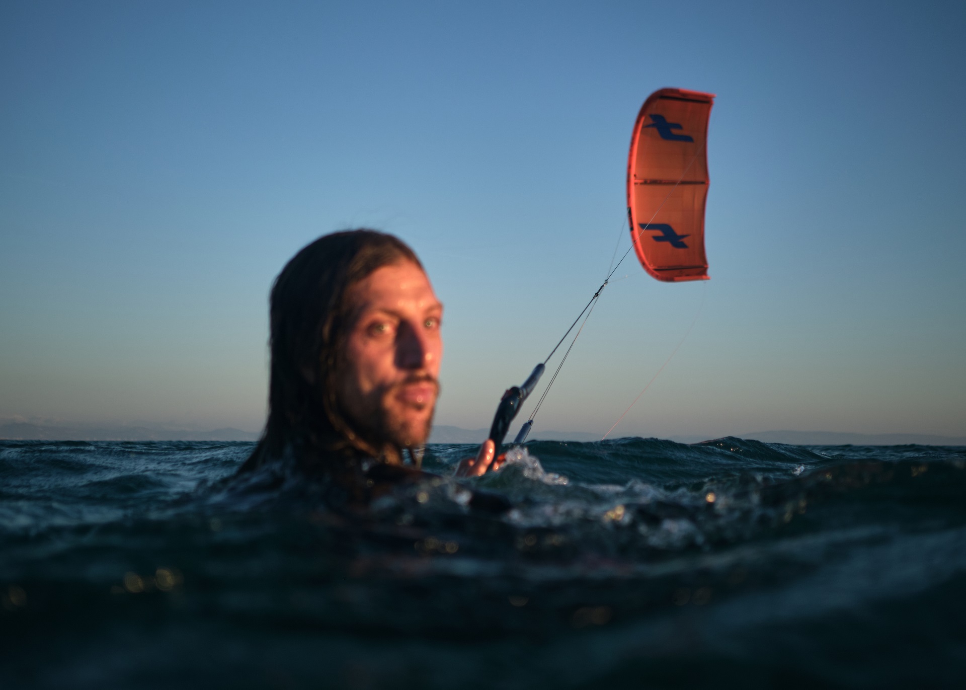 Alex body dragging in Tarifa during a kitesurf session in strong conditions.