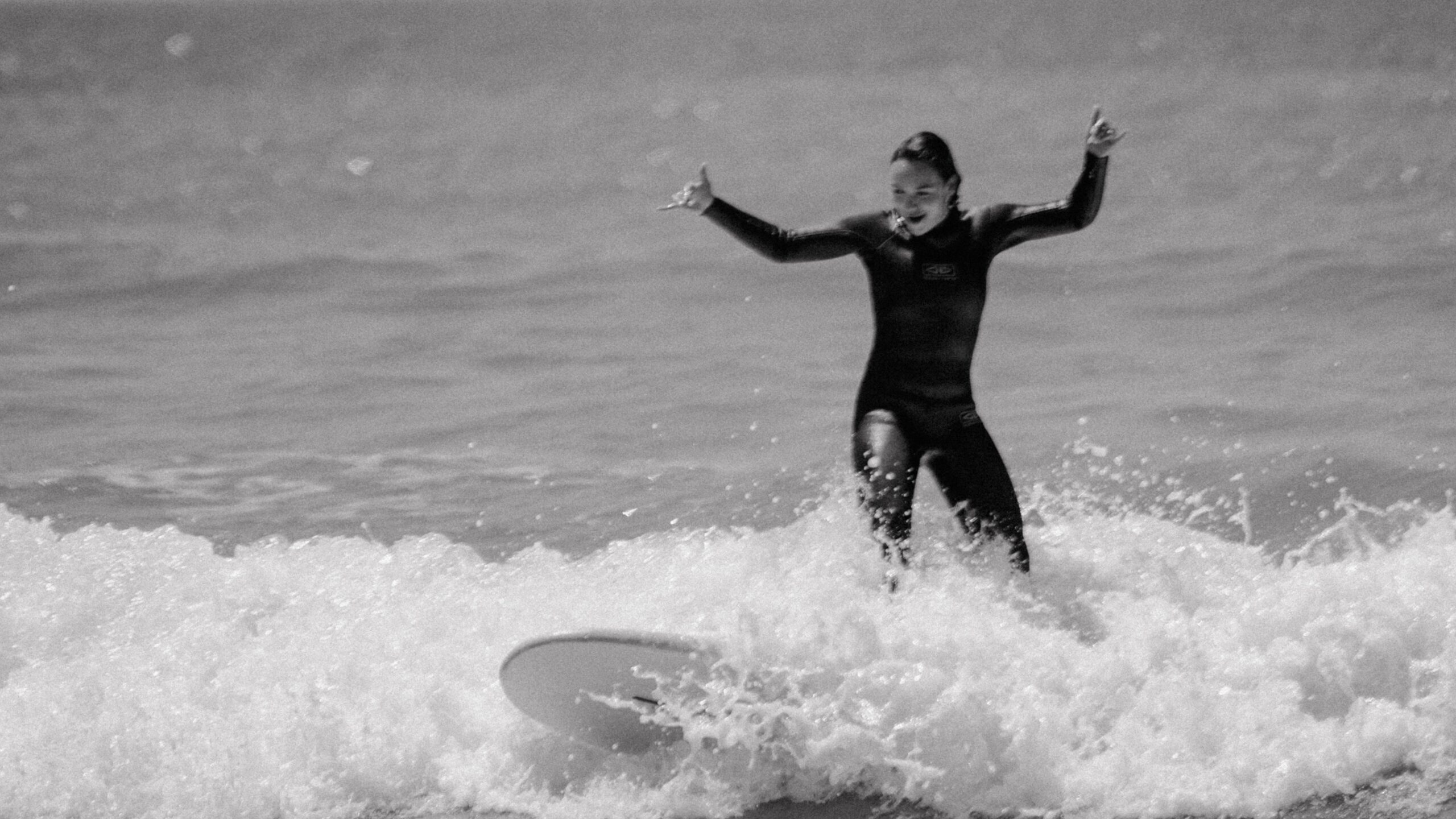 Kursantka łapiąca swoje pierwsze fale podczas lekcji surfingu w Tarifie. 